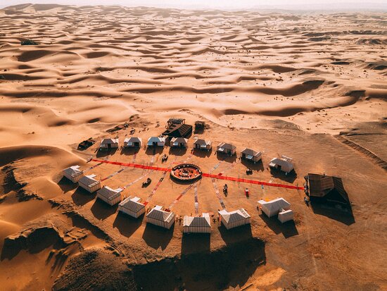 A camel caravan moving across the sand dunes of the Moroccan desert
